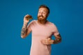 Happy hungry bearded man eating burger isolated on blue background Royalty Free Stock Photo