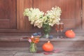 White hydrangea, glasses of rose champagne, helenium, autumn crocuses, figs and pumpkins are on steps of rustic wooden ladder Royalty Free Stock Photo