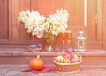 White hydrangea, rose champagne, lantern, figs, fruits and pumpkin are on steps of rustic wooden ladder