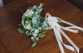 White hydrangea and roses wedding bouquet lying on the wooden table. Eucalyptus and beige ribbon for decoration. Elegant bridal Royalty Free Stock Photo