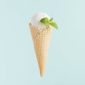 White ice cream cone scoop in waffle cone with mint leaf on soft light pastel green background, closeup, square. Royalty Free Stock Photo