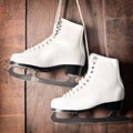 White ice skates for figure skating, hanging on wooden background Royalty Free Stock Photo