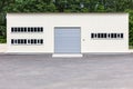 White industrial building facade with grey roller shutter gate