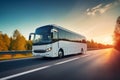 white intercity bus rides on highway, sunset