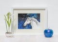 White interior display. Framed horses head painting, blue background.