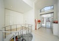 White interior of hall in luxury private house. Spiral staircase. Royalty Free Stock Photo