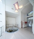 White interior of luxury private house. Glass and metal spiral staircase. Royalty Free Stock Photo