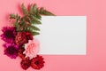 White invitation with flowers in a rosy background