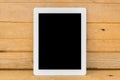 White ipad on brown wood table background