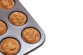 In selective focus homemade banana muffins in a black baking tray with almond sliced on top,