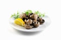 On a white isolated background, a plate dish with marinated whole champignon mushrooms, fresh lemon and dill Royalty Free Stock Photo