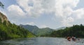 White Iyus river among hills and rock massifs. People float down the river on catamarans