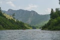 White Iyus river among hills and rock massifs. People float down the river on catamarans