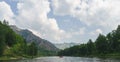 White Iyus river among hills and rock massifs. People float down the river on catamarans