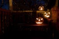 White jack o'lanterns on a bench at night