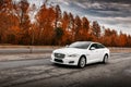 White Jaguar XJ car stand on wet asphalt road at daytime Royalty Free Stock Photo