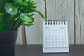 White January 2022 calendar with potted plant on wooden desk