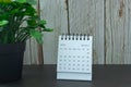 White January 2022 calendar with potted plant on wooden desk