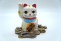 Maneki Neko lucky cat with coins on a white background