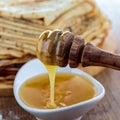 White jar full of honey that is filled with runny honey