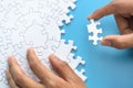 White jigsaw in the hands of humans, The correct solution. Teamwork, Solving and completing the task. Last piece of jigsaw puzzle Royalty Free Stock Photo