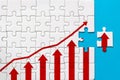 White jigsaw puzzle and graph arrow growth up on blue background Royalty Free Stock Photo