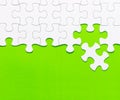 White jigsaw puzzle on green background Royalty Free Stock Photo