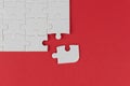 White jigsaw puzzle with missing piece on red background. Business build strong team work, partnership and leadership concept Royalty Free Stock Photo