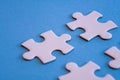 White jigsaw puzzle pieces on blue background with limited close up focus Royalty Free Stock Photo