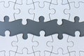 White jigsaw puzzle pieces on gray background Royalty Free Stock Photo
