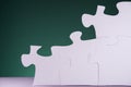 White jigsaw puzzle pieces on green background with copy space Royalty Free Stock Photo