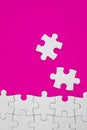 White jigsaw puzzle pieces on pink background with negative space Royalty Free Stock Photo