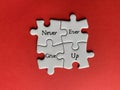 White jigsaw puzzle pieces and text - Never ever give up. Business and life motivational concept