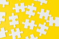 White jigsaw puzzle on solid yellow background metaphor solution to solving business problem, creativity, choice or teamwork