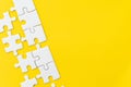 White jigsaw puzzle on vivid yellow background with copy space using for thinking strategy for business solution, teamwork,