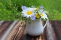 White jug with bouquet of meadow flowers on wooden table Royalty Free Stock Photo