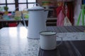 White kettel and mug with a kitchen in the background Royalty Free Stock Photo