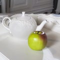 White kettle standing with green apple