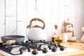 White kettle stands on the stove on the kitchen in the morning