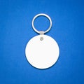 White key ring on blue background. Key chain for your design. Hanging accessory or souvenir.  Circle shape Royalty Free Stock Photo
