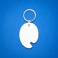 White key ring on blue background. Key chain for your design. Hanging accessory or souvenir.  Color tray shape Royalty Free Stock Photo