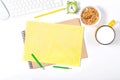 White keyboard, mouse, colorful stationery, clock, plate with granola and large cup of milk on white background. Royalty Free Stock Photo