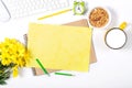 White keyboard, mouse, colorful stationery, yellow flowers, plate with granola and large cup of milk on white background. Royalty Free Stock Photo