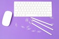 White keyboard and mouse on an ul purple background. Top view Royalty Free Stock Photo