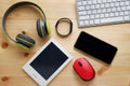 White keyboard with wireless mouse and bluetooth wireless headphones and other electronic gadgets for daily use on wooden Royalty Free Stock Photo