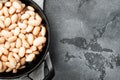White kidney beans, in cast iron frying pan, on gray stone background, top view flat lay, with copy space for text Royalty Free Stock Photo