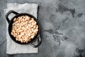 White kidney beans, in cast iron frying pan, on gray stone background, top view flat lay, with copy space for text Royalty Free Stock Photo