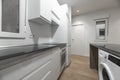 white kitchen with black countertops and white appliances
