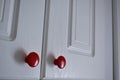 White kitchen cabinet with red knobs