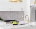 A white kitchen detail with gold light and faucet. Royalty Free Stock Photo